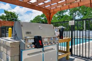 a grill sitting under a pergola next to a pool at TownePlace Suites by Marriott Jacksonville East in Jacksonville