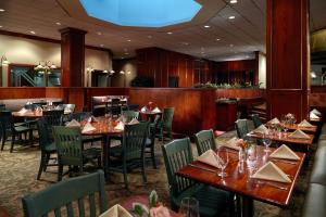 een eetkamer met houten tafels en stoelen bij Austin Southpark Hotel in Austin