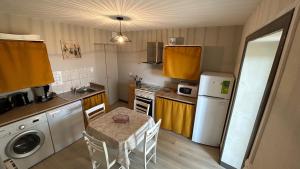 a small kitchen with a table and a kitchen with yellow cabinets at Gites Duguesclin in Saint-Coulomb