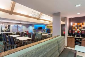 a restaurant with tables and chairs and a bar at Residence Inn Louisville Northeast in Louisville