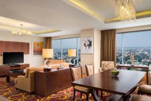 a living room with a table and a dining room at JW Marriott Hotel Medan in Medan