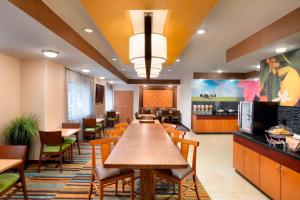 a dining room with a long table and chairs at Fairfield Inn & Suites by Marriott Dallas Plano in Plano