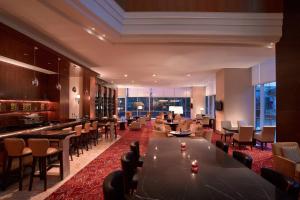 a restaurant with tables and chairs and a bar at JW Marriott Hotel Medan in Medan