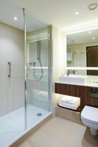 een badkamer met een douche, een toilet en een wastafel bij Courtyard by Marriott Aberdeen Airport in Dyce