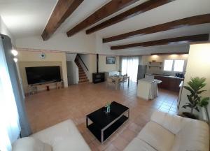 salon z białymi meblami i dużym telewizorem w obiekcie Villa avec plage à pied et grande piscine w mieście Sainte-Marie-la-Mer