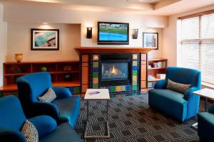 a living room with blue chairs and a fireplace at TownePlace Suites by Marriott Minneapolis Downtown/North Loop in Minneapolis