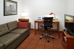 ein Wohnzimmer mit einem Sofa und einem Schreibtisch mit einem Computer in der Unterkunft TownePlace Suites by Marriott Minneapolis Downtown/North Loop in Minneapolis