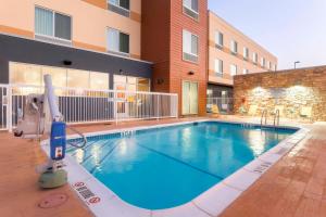 een groot zwembad voor een gebouw bij Fairfield Inn & Suites by Marriott Pleasanton in Pleasanton