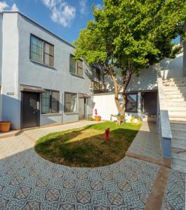 a building with a tree and a fire hydrant at Vesta Butik Otel in Edremit