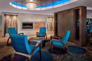 vestíbulo con sillas azules y chimenea en Fairfield Inn & Suites by Marriott Great Barrington Lenox/Berkshires, en Great Barrington