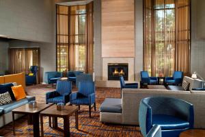 a lobby with blue chairs and a fireplace at Courtyard by Marriott Atlanta Alpharetta in Alpharetta