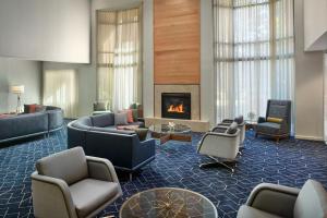 a lobby with couches and chairs and a fireplace at Courtyard by Marriott Atlanta Alpharetta in Alpharetta