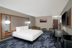 a hotel room with a bed and a flat screen tv at Fairfield Inn & Suites Memphis I-240 & Perkins in Memphis