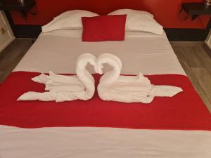 dois cisnes feitos de toalhas numa cama em Hotel Restaurant Le Manguier em Peyrat-de-Bellac