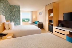 a hotel room with two beds and a flat screen tv at Fairfield Inn & Suites by Marriott Villahermosa Tabasco in Villahermosa