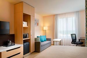 um quarto de hotel com uma cama e uma cadeira e uma televisão em Fairfield Inn & Suites by Marriott Villahermosa Tabasco em Villahermosa