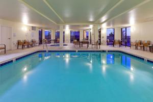 una piscina con mesas y sillas en una habitación de hotel en Courtyard Boulder Longmont, en Longmont