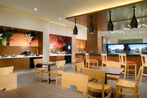 un restaurante con mesas y sillas y un bar en Fairfield Inn & Suites by Marriott Villahermosa Tabasco en Villahermosa