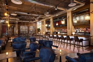 un restaurant avec des chaises bleues et un bar dans l'établissement Sheraton Grand Los Angeles, à Los Angeles