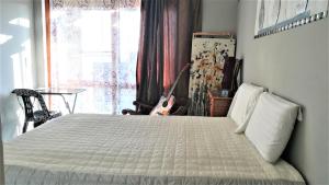 a bedroom with a bed and a guitar in a window at Lonehill in Sandton