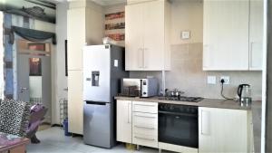 a kitchen with white cabinets and a refrigerator at Lonehill in Sandton