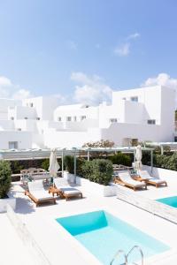 a pool on the roof of a hotel with lounge chairs at Astro Palace Hotel & Suites in Fira