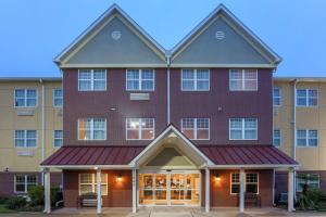 a large red brick building with a red awning at TownePlace Suites Houston Brookhollow in Houston