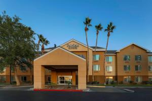 a hotel with palm trees in front of a building at Fairfield Inn & Suites by Marriott Yuma in Yuma