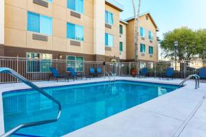 a swimming pool in front of a building with chairs at Fairfield Inn & Suites by Marriott Yuma in Yuma