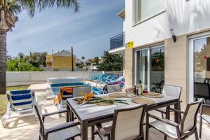 un patio avec une table et des chaises à côté d'une piscine dans l'établissement Villa Casa Vilas Boas, à Albufeira