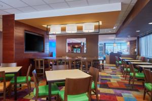 a dining room with tables and chairs and a flat screen tv at Fairfield Inn & Suites by Marriott Rawlins in Rawlins