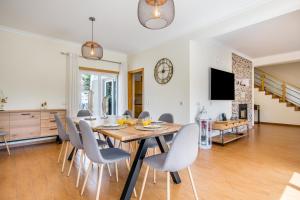 une salle à manger et un salon avec une table et des chaises dans l'établissement Villa Casa Vilas Boas, à Albufeira