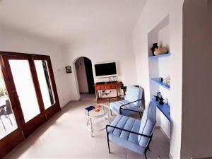 a living room with a couch and chairs and a television at Villa Perla Nou in Binibeca