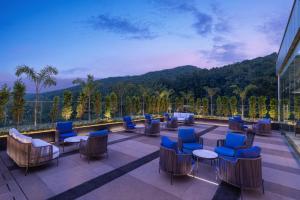 a balcony with chairs and tables on a building at Fairfield by Marriott Dehradun in Dehradun