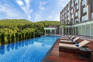 a hotel with a swimming pool and lounge chairs at Fairfield by Marriott Dehradun in Dehradun