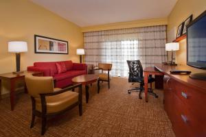 a hotel room with a red couch and a desk at Courtyard by Marriott Richmond West in Richmond