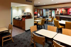 ein Restaurant mit Tischen und Stühlen und eine Küche in der Unterkunft TownePlace Suites by Marriott Texarkana in Texarkana - Texas