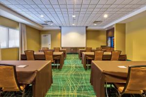 a conference room with tables and chairs and a screen at SpringHill Suites by Marriott Grand Rapids Airport Southeast in Cascade