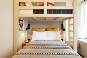 Moxy Richmond Downtown في ريتشموند: غرفة نوم مع سرير بطابقين وبجدران بيضاء