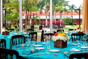 une table aménagée pour une fête avec des tables et des chaises bleues dans l'établissement Courtyard by Marriott Miami Airport, à Miami