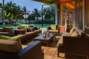 eine Terrasse mit Sofas, Stühlen und einem Tisch in der Unterkunft Courtyard by Marriott Miami Airport in Miami