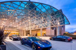 drei Luxusautos, die vor einem Gebäude geparkt sind in der Unterkunft The Westin Bayshore, Vancouver in Vancouver