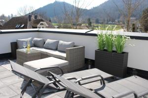 a patio with a couch and tables and chairs at Apartment Blicksüd in Unterburg am Klopeiner See