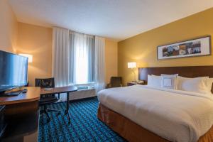 um quarto de hotel com uma cama, uma secretária e uma televisão em Fairfield Inn & Suites Savannah I-95 South em Savannah