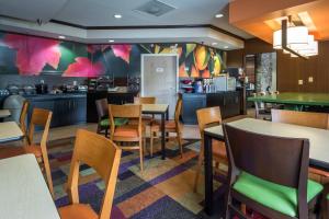 a restaurant with tables and chairs and a kitchen at Fairfield Inn & Suites Savannah I-95 South in Savannah