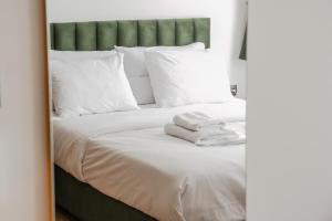 - une chambre avec un lit doté de draps blancs et d'un miroir dans l'établissement Sun Marco Apartments in Athens, à Athènes
