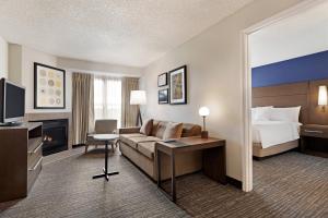 a hotel room with a couch and a bed at Residence Inn by Marriott Roseville in Roseville +16 photos