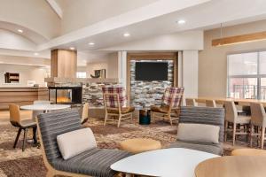 a lobby with tables and chairs and a fireplace at Residence Inn by Marriott Roseville in Roseville