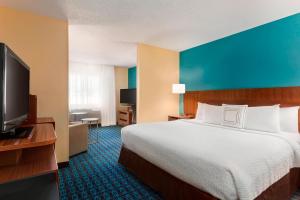 a hotel room with a bed and a flat screen tv at Fairfield Inn & Suites Mankato in Mankato