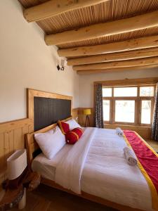 um quarto com uma cama grande e uma janela em Namra Villa em Leh